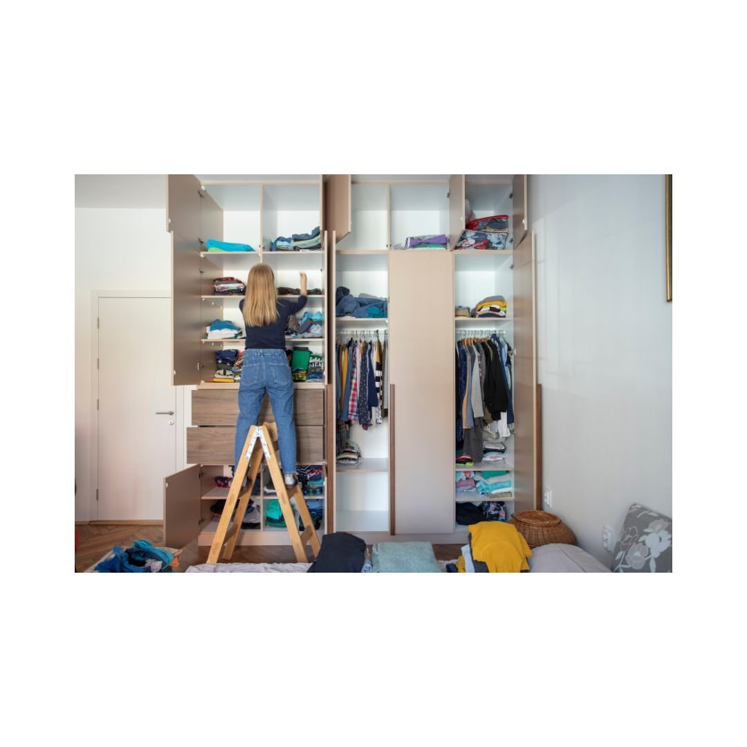 A woman throwing away items from her closet