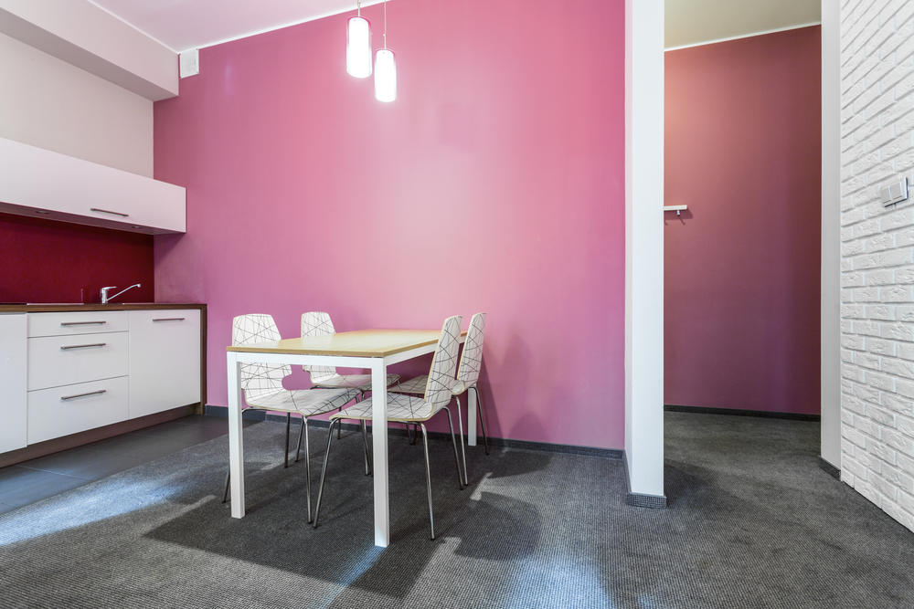a small kitchen with a pink wall