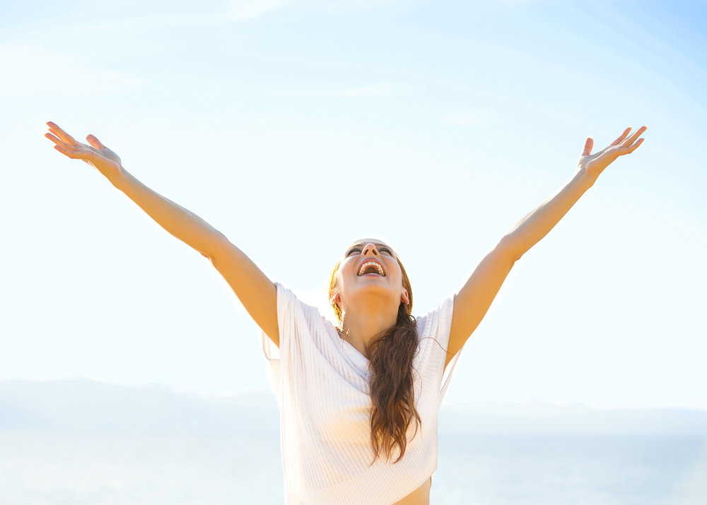 woman smiling arms raised